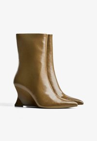 Botine negre din piele cu toc wedge, cu un finisaj neted, vârf ascuțit și un design elegant, conturat pentru un aspect modern.