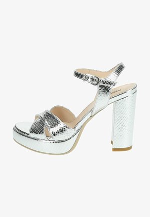 Sølv platform hæl sandaler med tekstureret slangeskindsmønster. Har justerbar ankelrem og brede crossover stropper samt en glat inderside.