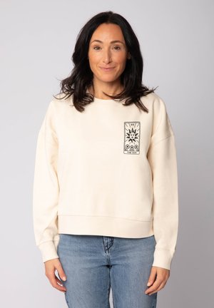 Beige sweatshirt made of soft fabric with a relaxed fit, featuring a printed graphic of a sun. Cuffs and hem are ribbed for texture.