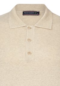 Beige polo shirt met een getextureerde kraag, drie knopen en een subtiel breipatroon. Merkenlabel "FELIX HARDY" zichtbaar bij de halslijn.