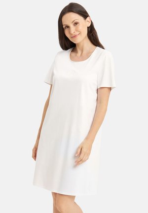 Nuisette blanche à manches courtes en tissu doux, avec un décolleté en arrondi et un motif discret embossé sur la poitrine.