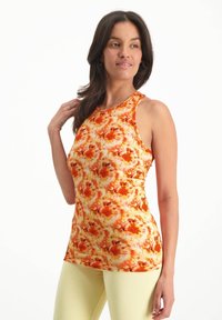 Ärmlös topp i en livfull blommönstring med orange, gult och rödtoner. Tillverkad av stretchigt tyg med en figurnära passform.