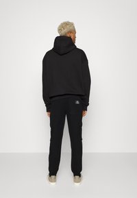 Redefined Rebel ARCHER PANTS UNISEX  - Calças de fato de treino - black