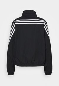 Schwarze Sportjacke mit hohem Kragen, elastischem Saum und langen Ärmeln, die jeweils drei weiße Streifen auf jeder Schulter hat.