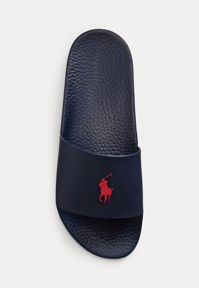 Navy blue slide sandal with textured footbed and wide strap featuring a red polo player logo centered on top.