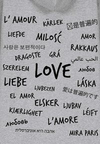 Felpa grigia con parole "amore" in varie lingue stampate in grassetto nero e un piccolo logo con la scritta "MIRA PARIS".