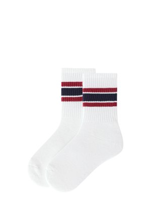 Calzini bianchi da crew con polsini a coste che presentano due strisce rosse e una striscia blu navy al centro del polsino.