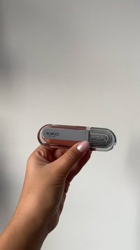KIKO Milano lipgloss i en rund, gennemsigtig beholder med en lyserød bund og sølvdetaljer; klar applikator synlig indeni.