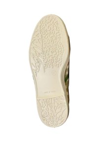 Semelle d'une chaussure en matériau en caoutchouc texturé de couleur crème clair, ornée de rainures et de motifs surélevés pour une traction accrue.