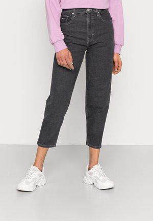 Mørkegrå højtaljede jeans med lige ben, der har en lys vasket tekstur og diskrete syninger. Parret med hvide sneakers.