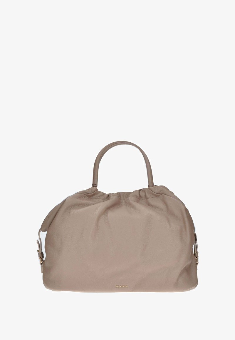 Zachte beige leren handtas met een gathered top ontwerp, dubbele ronde handvatten en subtiele gouden branding op de voorkant.