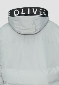 Lichtgrijze pufferjack met een capuchon, voorzien van een zwart kraagaccent met witte opdruk. Gladde textuur en minimale stikdetails.