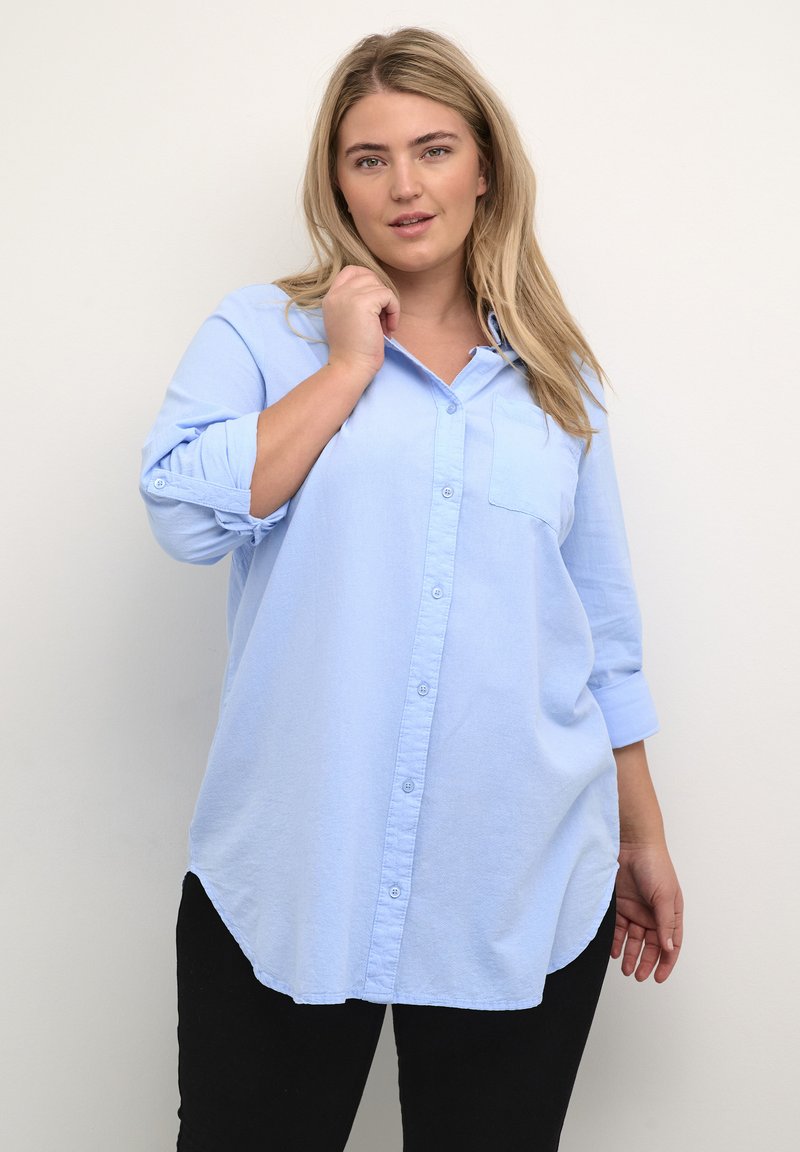 Lichtblauwe, langemouw, knoopsluiting blouse met een borstzak, een afgeronde zoom en opgerolde mouwen, gemaakt van een zachte, gestructureerde stof.