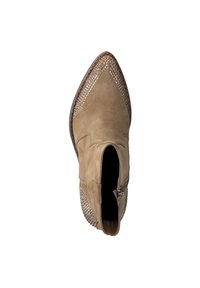Bottine en suede marron à bout pointu, avec des clous en métal décoratifs sur les côtés et une fermeture éclair sur le côté. Semelle plate.