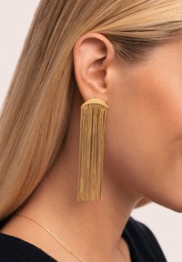 Pendientes en tono dorado que presentan una sección superior curva con múltiples cadenas en cascada, creando un diseño texturizado y alargado.