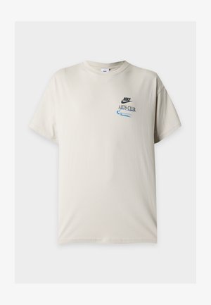 Μπεζ κοντομάνικη μπλούζα Nike με στρογγυλή λαιμόκοψη, μικρό μαύρο λογότυπο Nike και μπλε κείμενο "Arts Club" στο αριστερό στήθος.