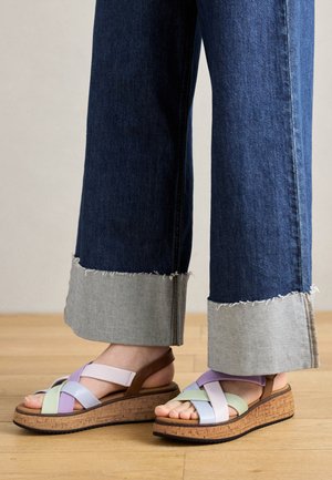 Sandales compensées avec des brides multicolores en lilas clair, vert menthe et bleu pâle, dotées d'une semelle en liège et d'accents marron.