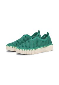 Para zielonych butów wsuwanych z falistymi wzorami i grubymi, białymi, ryflowanymi podeszwami, wyposażonych w paski ułatwiające zakładanie na pięcie.