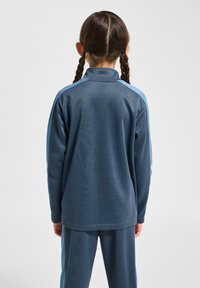 Lichtgewicht fleecejack in marineblauw met een hoge kraag en contrasterende lichtblauwe schouderpanelen. Voorzien van lange mouwen en een ontspannen pasvorm.