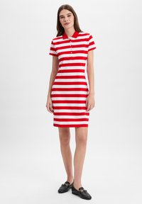 Rood-wit gestreepte korte mouwen polo jurk met een kraag en knoopsluiting, getailleerde stijl, gecombineerd met zwarte instappers.