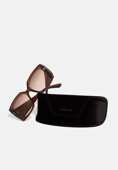 Brown gradient sunglasses with angular frames, gold accents, and Tom Ford logo, alongside a black velvet protective case.