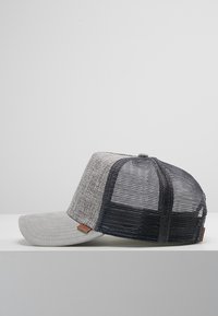 Grey cap with a textured fabric front and mesh back. Features a flat bill and a brown leather logo patch on the side.