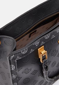 Černá kožená kabelka s embosovanými logy, zlatými kovovými doplňky a texturovanými akcenty. Interiér obsahuje vzorovanou podšívku a kapsu na zip.