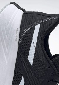 Primer plano de una zapatilla deportiva negra de lado con suela blanca etiquetada "Floatride Fuel" y costuras detalladas en la parte superior de malla.