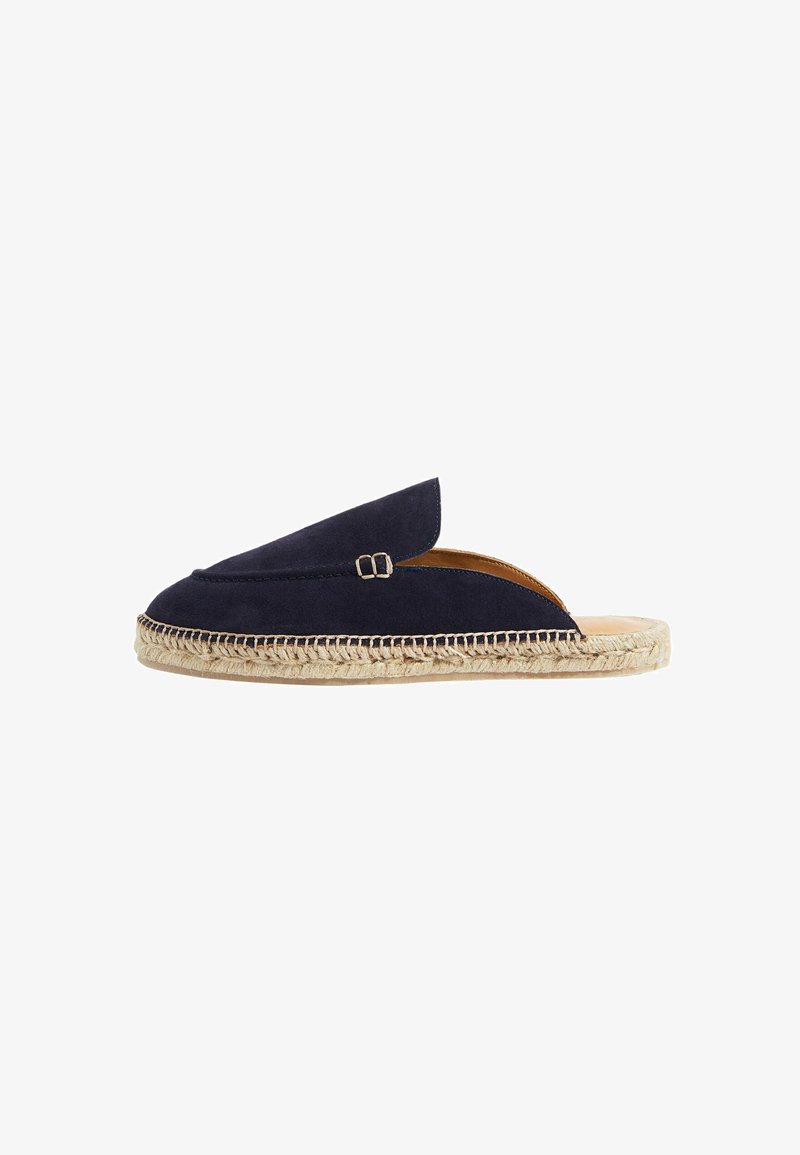 Espadrilla de ante azul marino con abertura en la parte trasera, que cuenta con una suela de yute tejido y un detalle decorativo de hebilla en la parte superior. Diseño plano y minimalista.