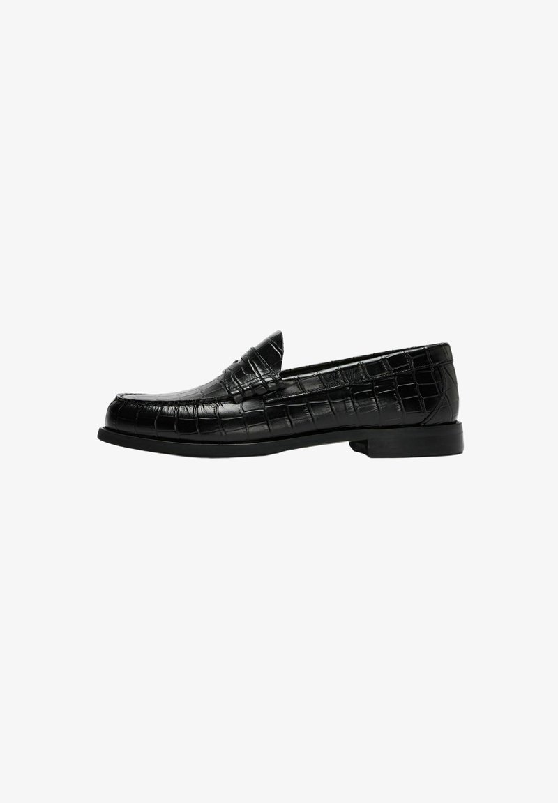 Mocassin en cuir noir pour homme avec texture crocodile et petit talon, présenté en profil sur fond blanc.