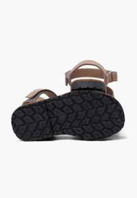 Sandali in pelle marrone con molteplici cinturini, dotati di una suola in gomma nera testurizzata e chiusure regolabili in Velcro.