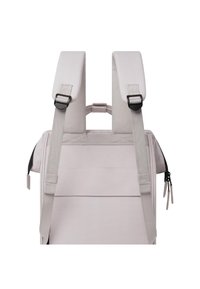 Sac à dos gris clair avec larges bretelles rembourrées. Comprend des sangles de poitrine réglables et des poches latérales zippées pour plus de commodité.