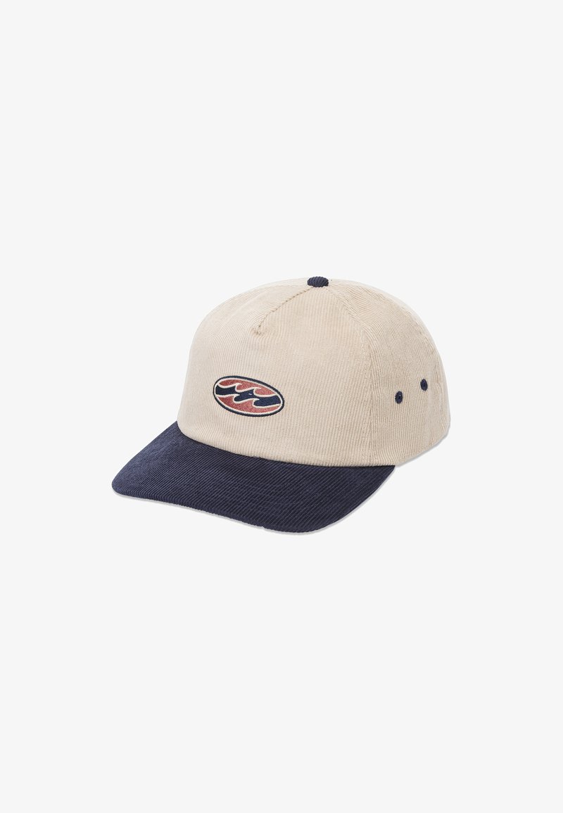 Beige Cordura-Kappe mit einem marineblauen Schirm, ausgestattet mit einem gestickten Logo in Rot und Blau. Details sind die Nähte und Lüftungsöffnungen.