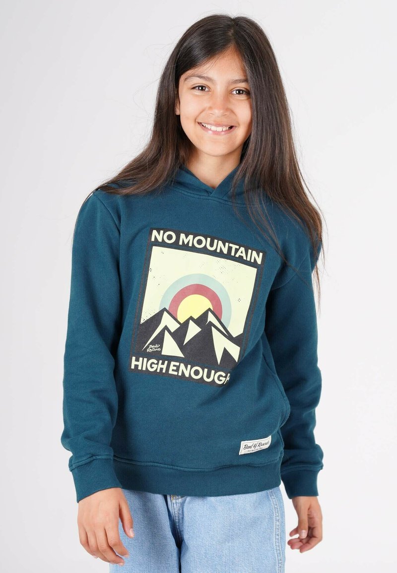 Teal hættetrøje med et frontgrafik af bjerge og en sol; teksten lyder "INGEN BYGNING FOR HØJT." Ribbenede manchetter og søm, afslappet pasform.