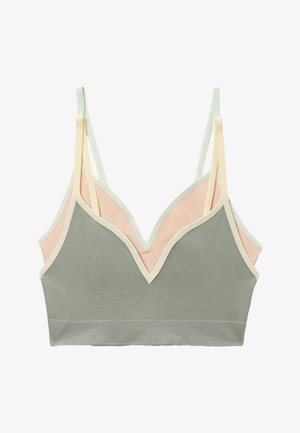 Bralette côtelée douce avec double bretelles fines, présentant des panneaux avant vert sauge et arrière pêche pâle, bordée d'un liseré blanc cassé.