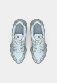 Αθλητικά παπούτσια σε ανοιχτό γαλάζιο χρώμα με υφή στο πάνω μέρος, ελαστική σόλα και εμφανές επίπεδο σχέδιο. Περιλαμβάνουν ανακλαστικές λεπτομέρειες στα κορδόνια.