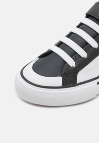 Sneaker bianco e nero con tomaia in pelle liscia, punta a contrasto, lacci bianchi e suola in gomma testurizzata.