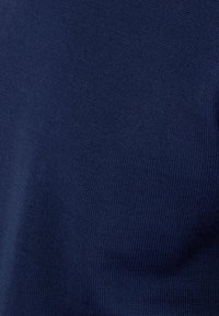 Tela de punto azul marino, tejida de forma apretada con una textura suave. Sin patrones visibles ni detalles metálicos.