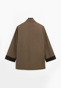 Brown shirt with a high collar, three-quarter sleeves, and dark cuffs. Smooth texture and minimalistic design, shown from the back.