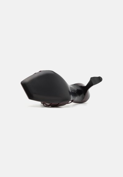 Cizmă neagră cu toc înalt, cu vârf ascuțit și toc unghiular unic. Finisaj neted și lucios, cu un design sculptural.