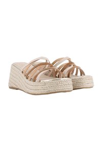 Sandalias de cuña con suela de yute trenzado, que cuentan con múltiples correas en tono marrón cruzando el pie y una plantilla suave en color nude.