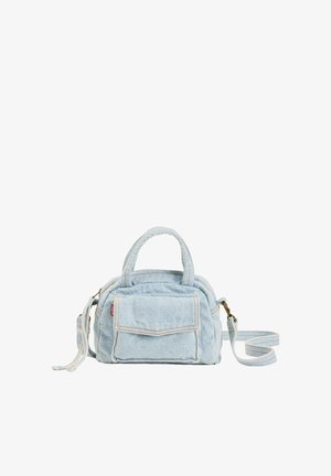 Petit sac à main en denim bleu clair avec une poche avant à rabat, deux poignées et une bandoulière amovible, isolé sur fond blanc.