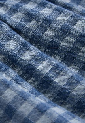 Tessuto a scacchi blu con quadrati alternati chiari e scuri. Trama texturizzata, finitura morbida e aspetto leggermente stropicciato.