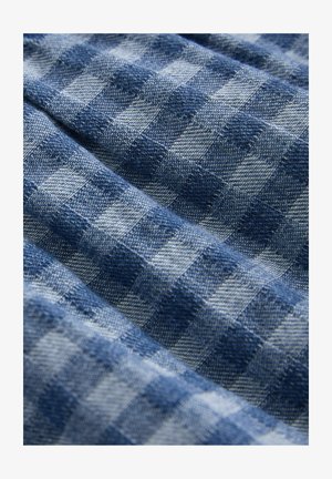 Tessuto a scacchi blu con quadrati alternati chiari e scuri. Trama texturizzata, finitura morbida e aspetto leggermente stropicciato.