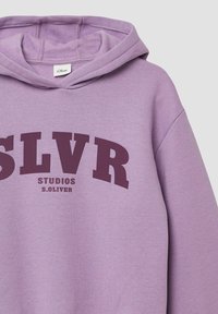 Felpa viola chiaro realizzata in tessuto morbido, caratterizzata da una grande grafica testuale in un intenso colore viola scuro: "SLVR STUDIOS S.OLIVER" in un carattere audace.