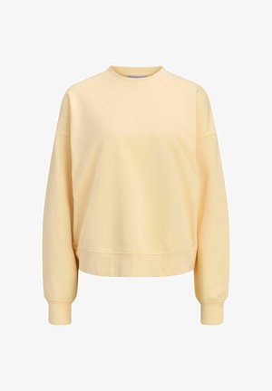 Dzeltena, pārmērīgi liela džemperis, izgatavots no mīksta auduma. Ar apaļu kaklu, nokrišanas pleciem un ribotām piedurknēm, ar īsu apakšmali.