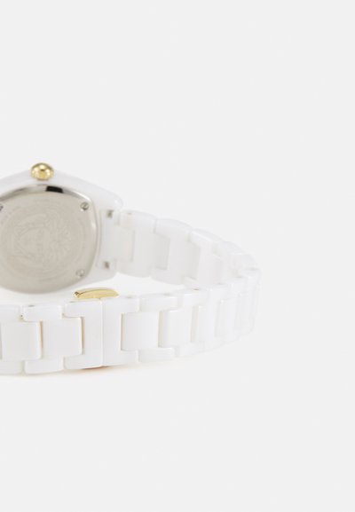 Weißer Keramikuhren mit quadratischem Gehäuse, goldenen Akzenten und einem glänzenden Gliederarmband. Der Edelstahlboden zeigt ein dekoratives Emblem.