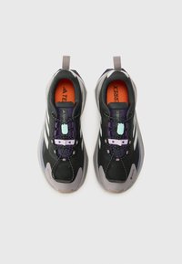 Chaussures de randonnée noires avec des accents violets et gris. Elles disposent d'un dessus respirant, d'un système de lacets et d'une semelle texturée pour une meilleure adhérence.