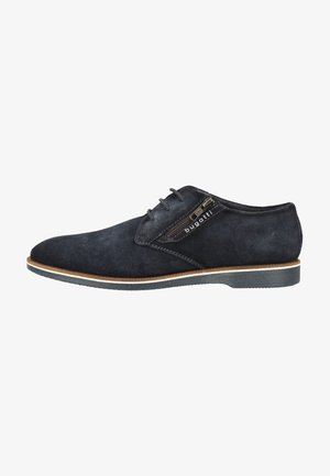 Chaussure pour homme en daim bleu foncé avec lacets, fermeture éclair latérale et semelle bordée de marron, estampillée "bugatti" sur le rabat de la fermeture éclair.