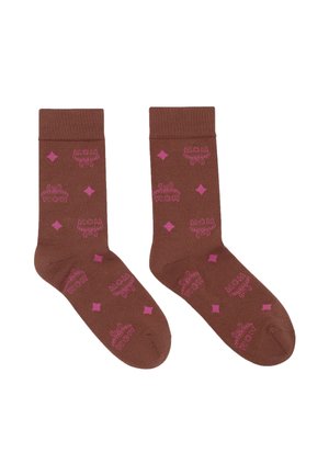 Paire de chaussettes marron mi-mollet avec motifs losanges roses et logos MCM roses répétés sur fond blanc.